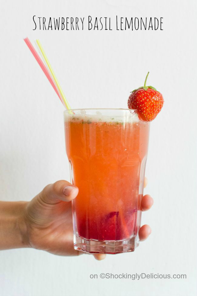 Strawberry Basil Lemonade in a glass with straws and a berry garnish on ShockinglyDelicious.com