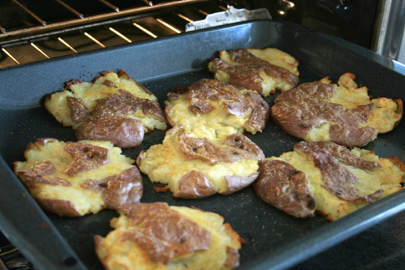 8 smashed potatoes in a pan in the oven