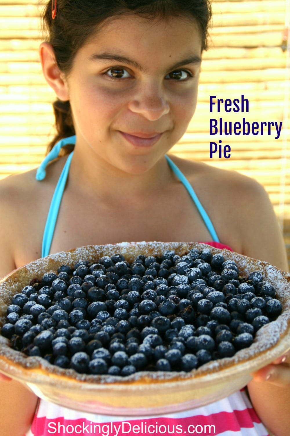 Young girl shows off a whole Fresh Blueberry Pie on ShockinglyDelicious.com