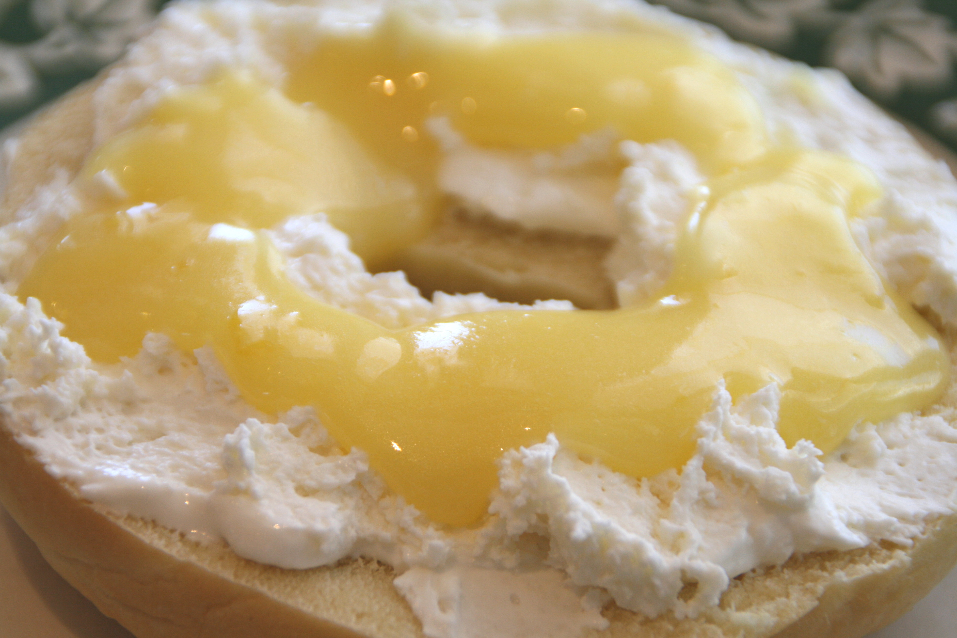 Bagel spread with cream cheese and lemon curd on top