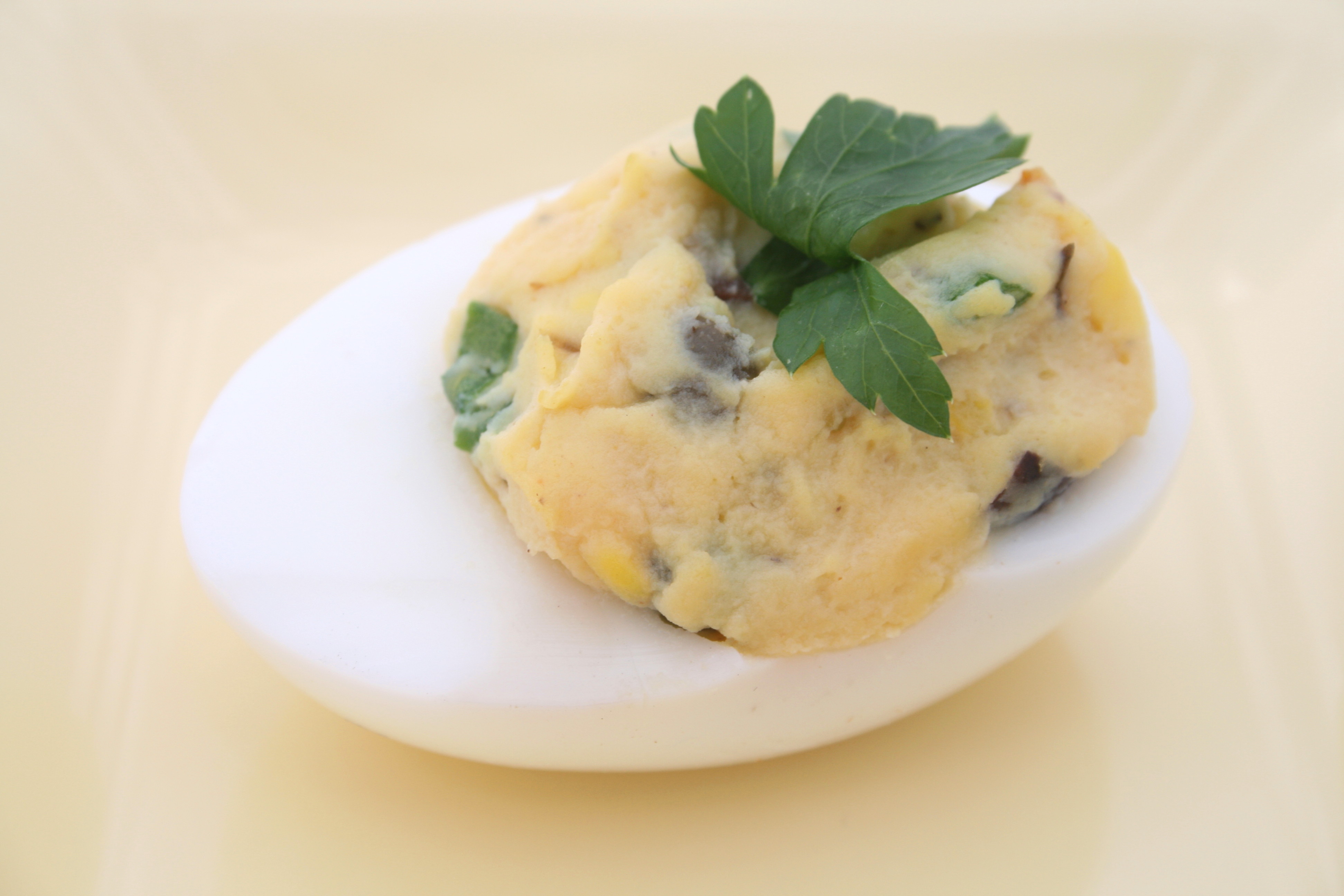 Mediterranean Deviled Egg on a light yellow background