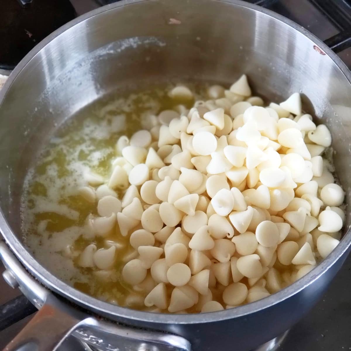 Butter and white chocolate melting on the stove in a small silver pot