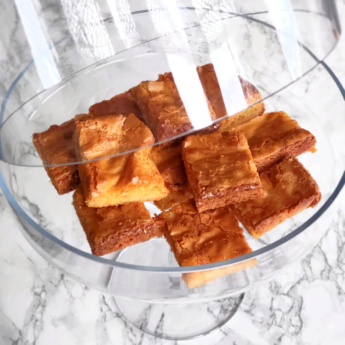 White Chocolate Blondies in a glass bakery-style stand with the glass dome lid lifted