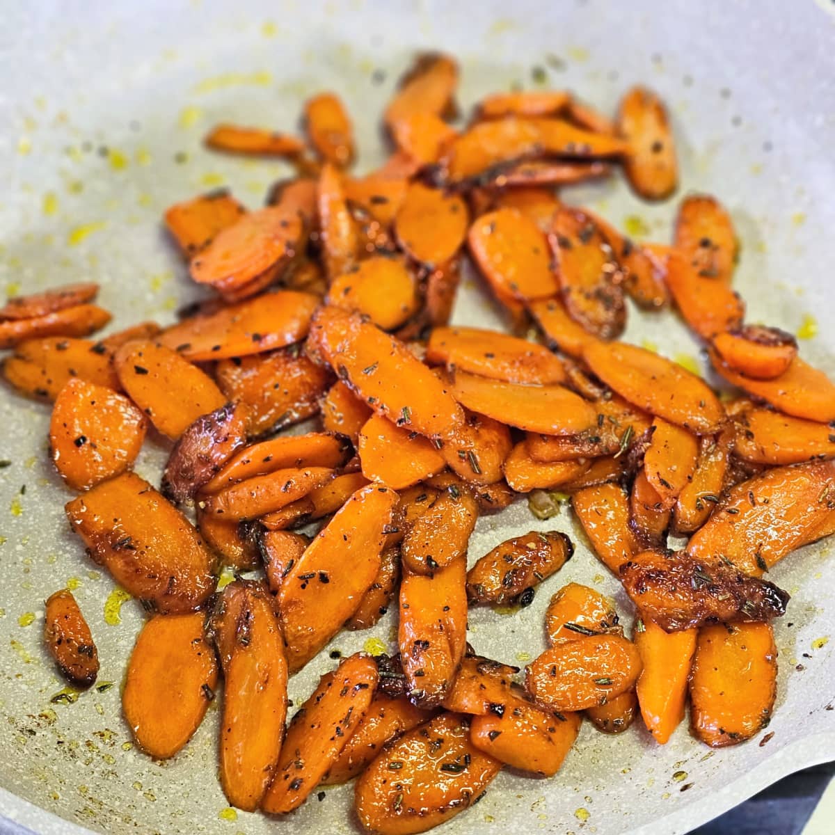 Sliced carrots in a light colored skillet