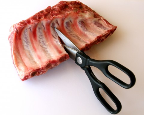Cutting baby back ribs with scissors 