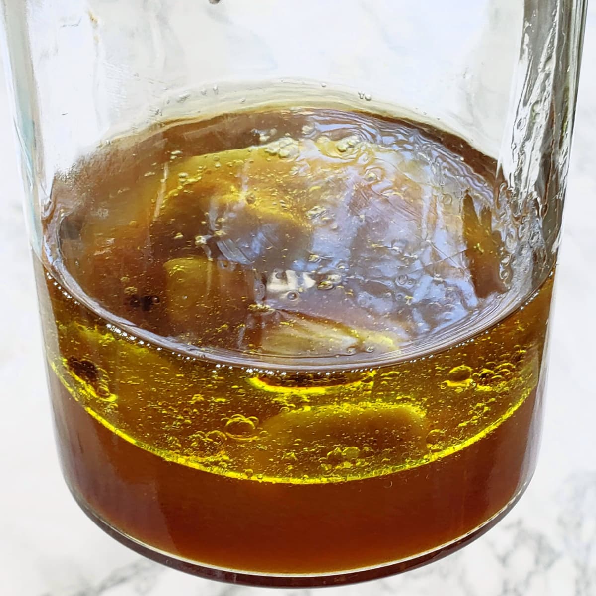 Sweet Miso Dressing ingredients in a glass jar against a marble countertop, ready to blend