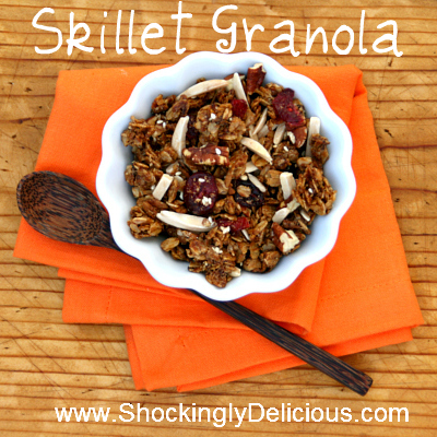 Skillet Granola in a white bowl on an orange napkin with a brown spoon alongside