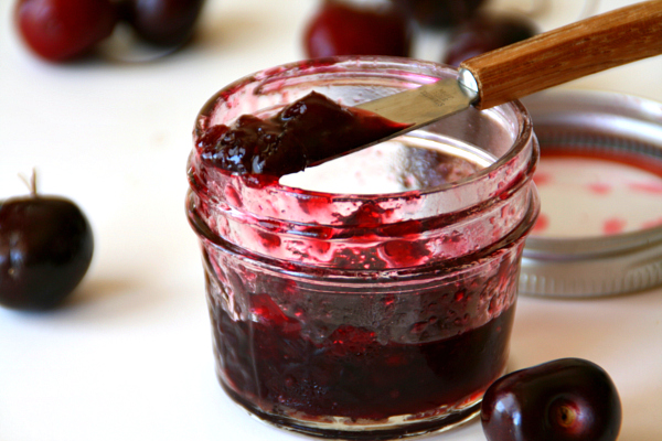 Bing Cherry Jam with cherries around it on the counter