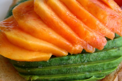 Close up on the peach and avocado slices on toast