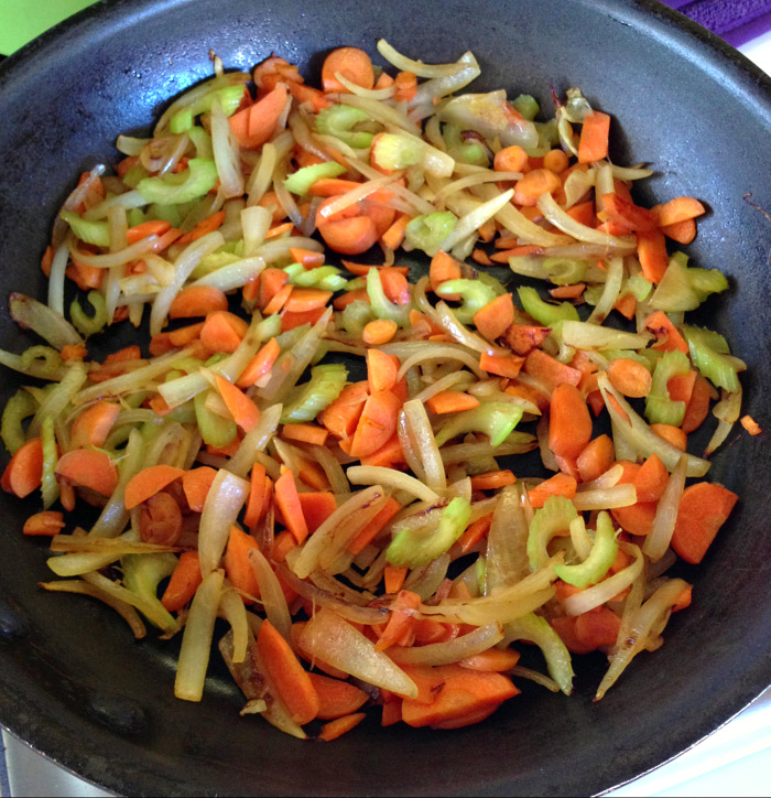 Carrots, celery and onions in a black skillet 
