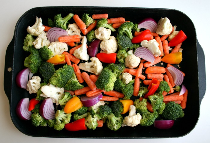 Mixed vegetables in a black baking dish on a white counter on Shockingly Delicious