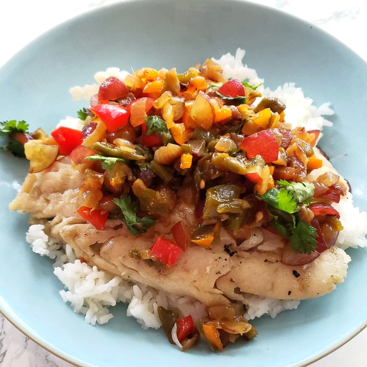 Hatch Chile Grape Salsa atop fish and rice in a light blue bowl