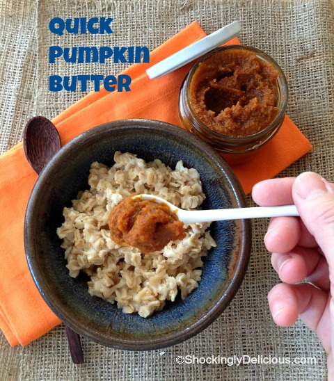 Hand holds a white spoon that has pumpkin button on it over a bowl of oatmeal