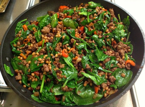 Ground lamb, spelt and spinach in a skillet