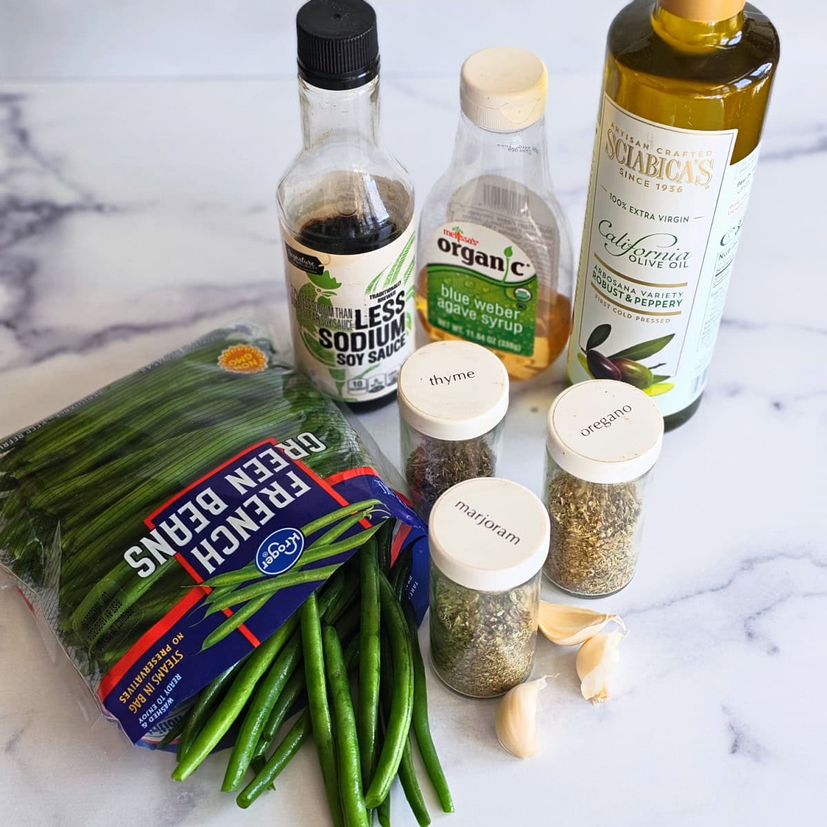 Ingredients for Sweet and Savory Green Beans on a white marble counter. 