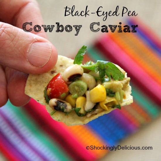 Black-Eyed Pea Cowboy Caviar on a corn chip against a Mexican fabric background