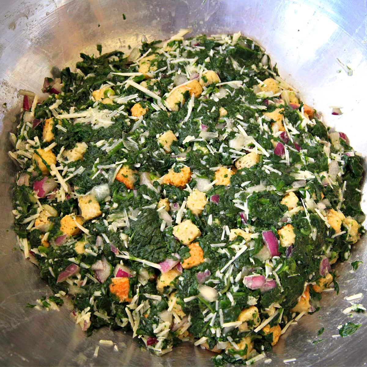 Spinach Ball mixture resting in stainless steel mixing bowl