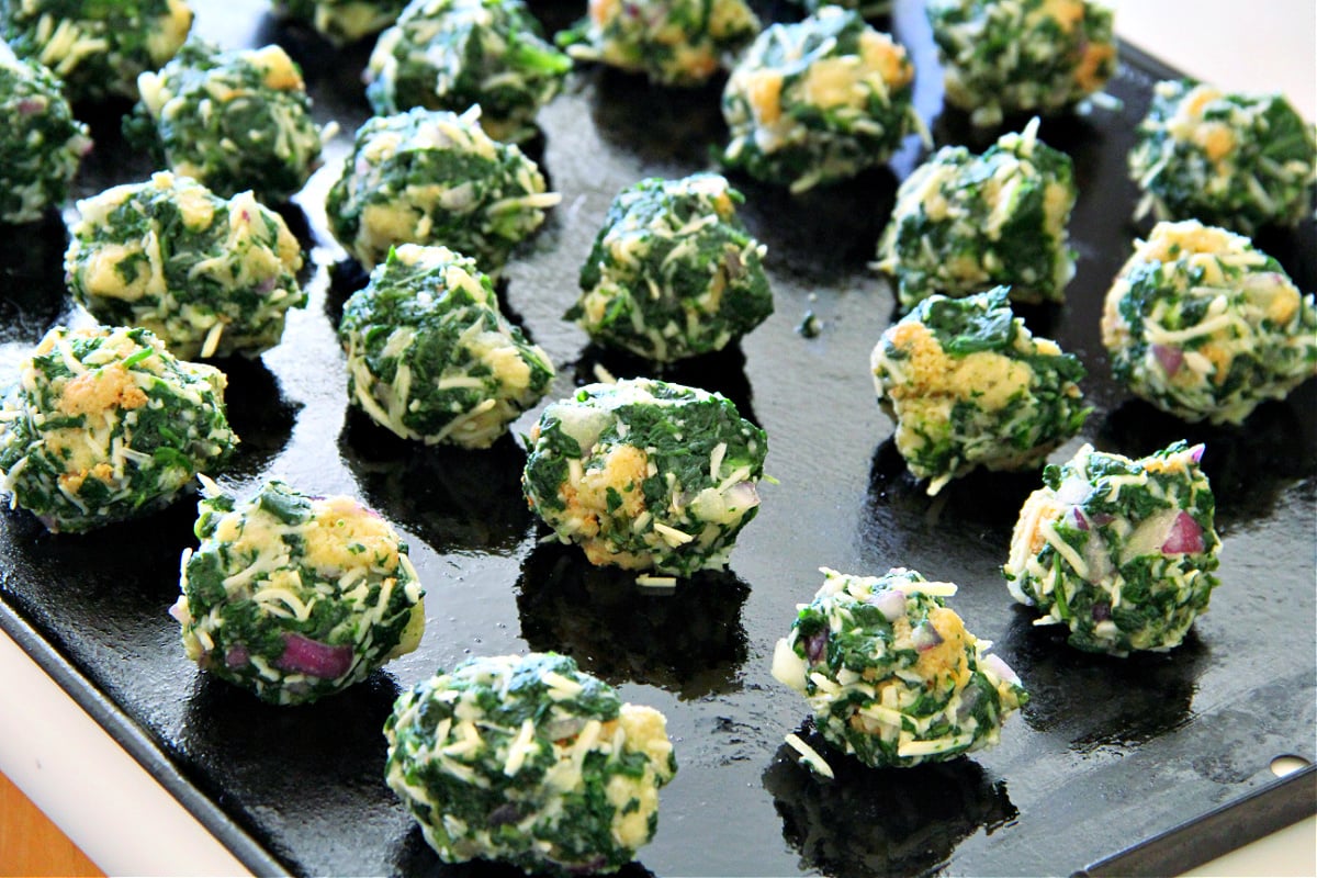 Spinach Balls on a black baking sheet