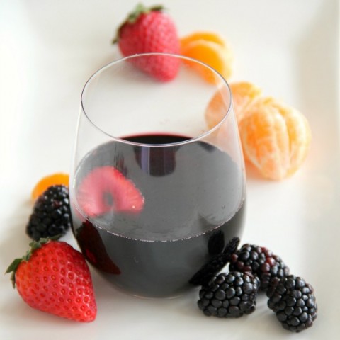 Fruity Burgundy Sangria in a glass with berries alongside | www.ShockinglyDelicious.com