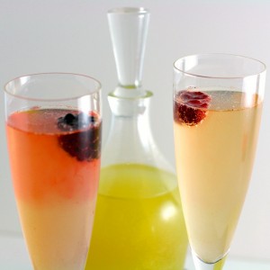 2 champagne flutes filled with berries floating on top