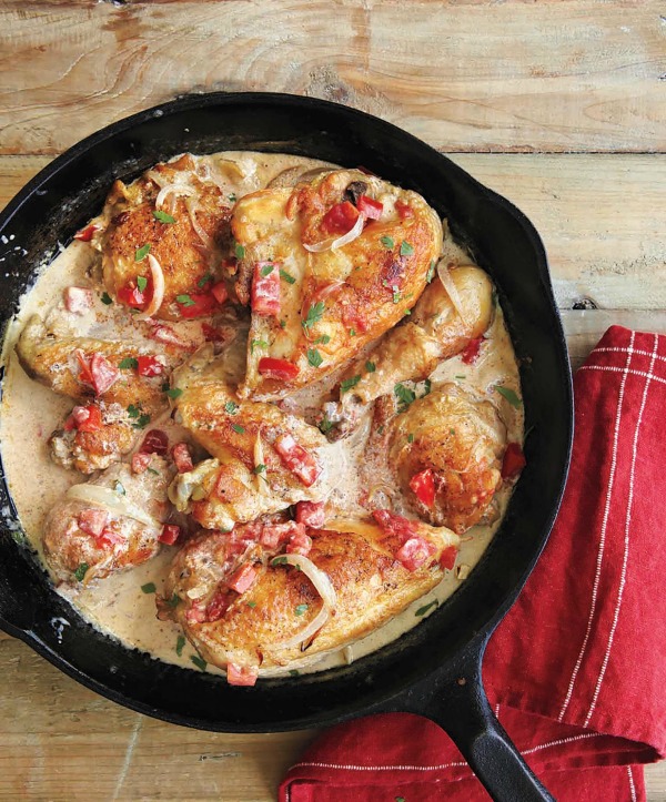 Pollo En Crema in a cast iron skillet on a wooden table on Shockingly Delicious