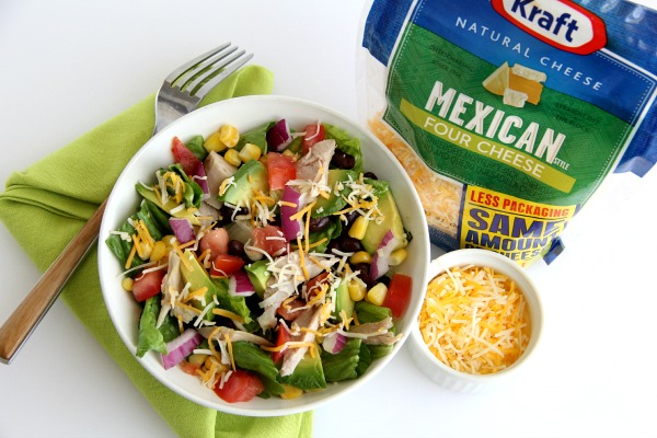 Salad in white bowl next to bag of Mexican cheese | Shockingly Delicious.com