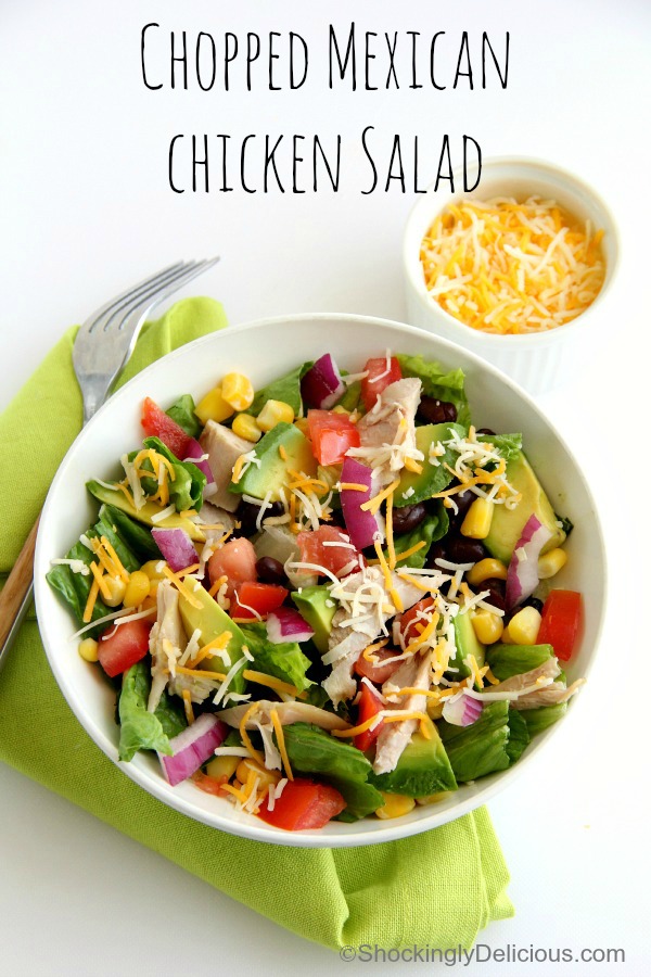 Chopped Mexican Chicken Salad on a green napkin with bowl of cheese on the side | Shockingly Delicious.com