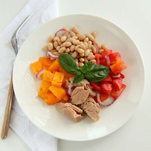 Tuna, Tomato, Bean and Basil Salad in a white bowl with a white napkin beside it