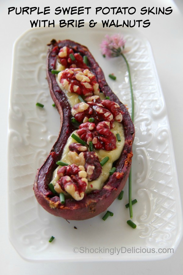 Purple Sweet Potato Skins with Brie and Sweet Walnuts on a white textured rectangular plate with a chive flower along the side | Shockingly Delicious