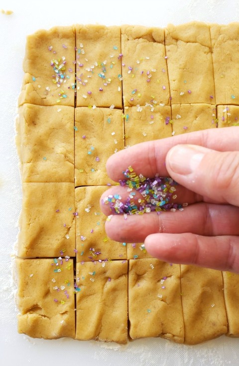 Sprinkle Brown Sugar Shortbread with sugar crystals on ShockinglyDelicious.com