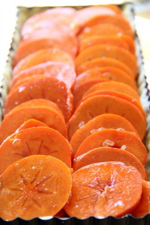 Sliced persimmons in tart shell for Persimmons Tart on ShockinglyDelicious.com