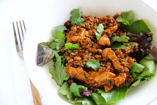 Healthy Turkey Lentil Taco Salad in a white bowl with a fork alongside