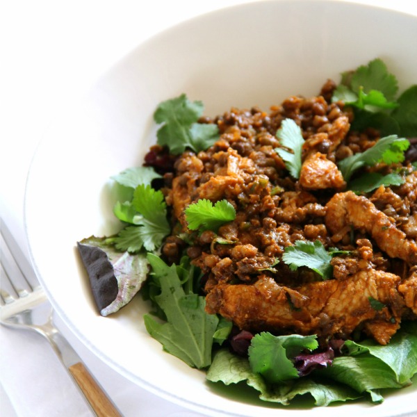 Turkey Lentil Taco Salad over salad greens in a white bowl with a fork alongside