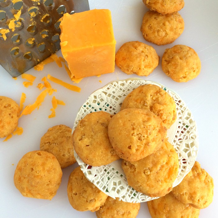 Cheese Crispies on a serving plate with a cheese grater and a block of cheese alongside