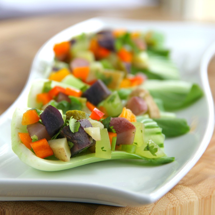 Potato Salad in baby bok choy cups on a white curvy serving plate