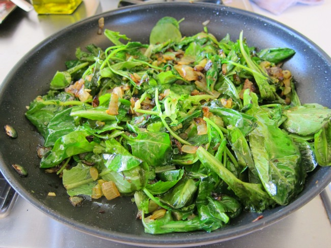 Onions, celery and greens wilting in the skillet on ShockinglyDelicious.com