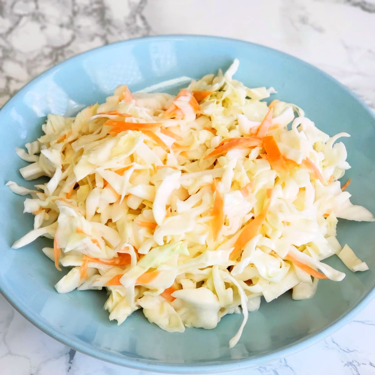 Chick-Fil-A Cole Slaw original recipe on ShockinglyDelicious.com Chick-Fil-A Cole Slaw original recipe in a light blue bowl on ShockinglyDelicious.com