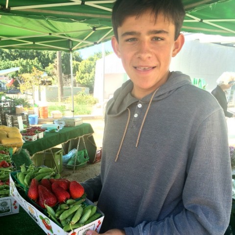 Buying sugar snap peas and strawberries at the farmers market on ShockinglyDelicious.com