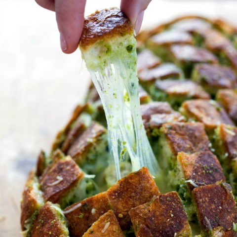 Cheesy Pull-Apart Pesto Bread: People will go crazy for this Cheesy Pull-Apart Pesto Bread that's like garlic knots gone wild. Cross cutting the bread makes the loaf easy to pull apart. | ShockinglyDelicious.com