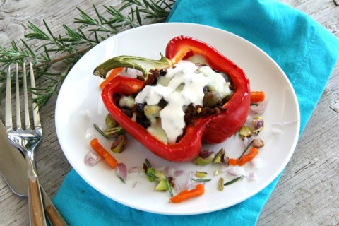 Soy chorizo takes the place of traditional beef in this delicious vegetarian Picadillo Stuffed Peppers with chorizo, lentils, cauliflower and mushrooms.  A sweet-savory garnish includes dried apricots, pistachios, rosemary and a drizzle of crema. | ShockinglyDelicious.com
