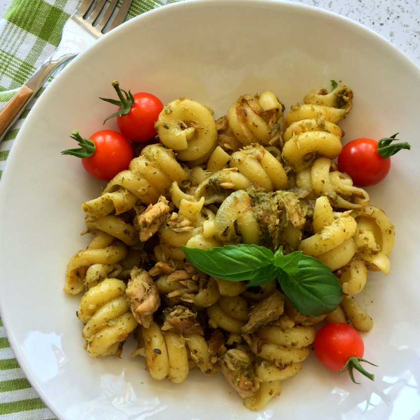 Easy Tuna Pesto Pasta recipe in a white bowl with green striped napkins under the bowl on ShockinglyDelicious.com