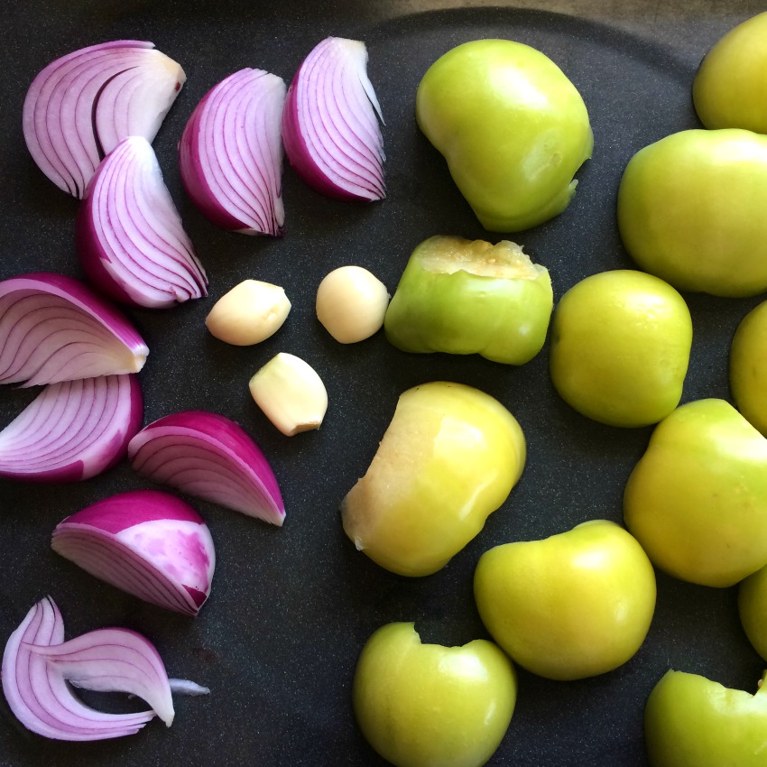 Onion garlic and tomatillos ready for the oven on ShockinglyDelicious.com