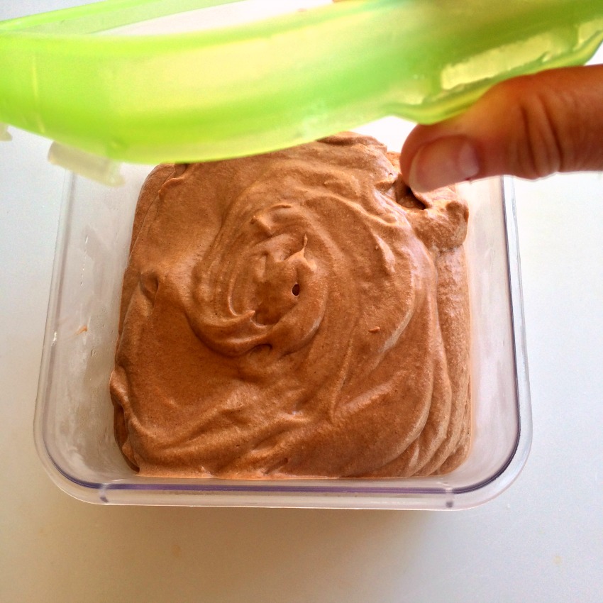 A hand puts the bright green lid on a plastic container of Milk Chocolate Ice Cream on Shockingly Delicious.com