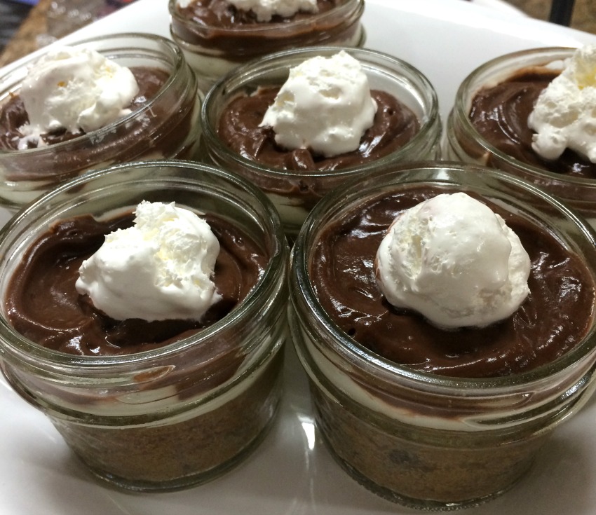 cookie-pudding-pie-cups in short Mason jars with dollops of whipped cream on top 