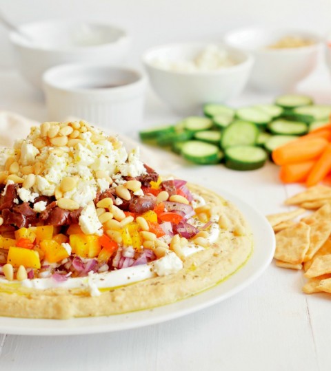 Greek Seven-Layer Dip gives a Greek twist to the traditional layered dip with hummus as the base, and yogurt, olives and feta as toppings.