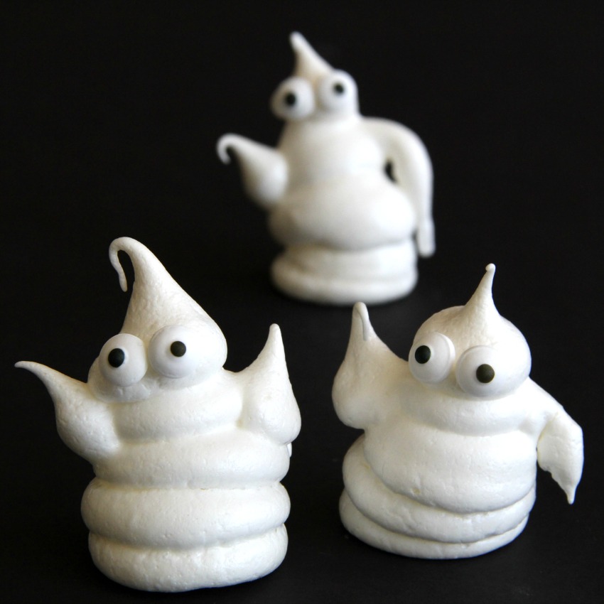 3 haunted-halloween-ghost meringue cookies-against a black background on-shockinglydelicious-com-meringue