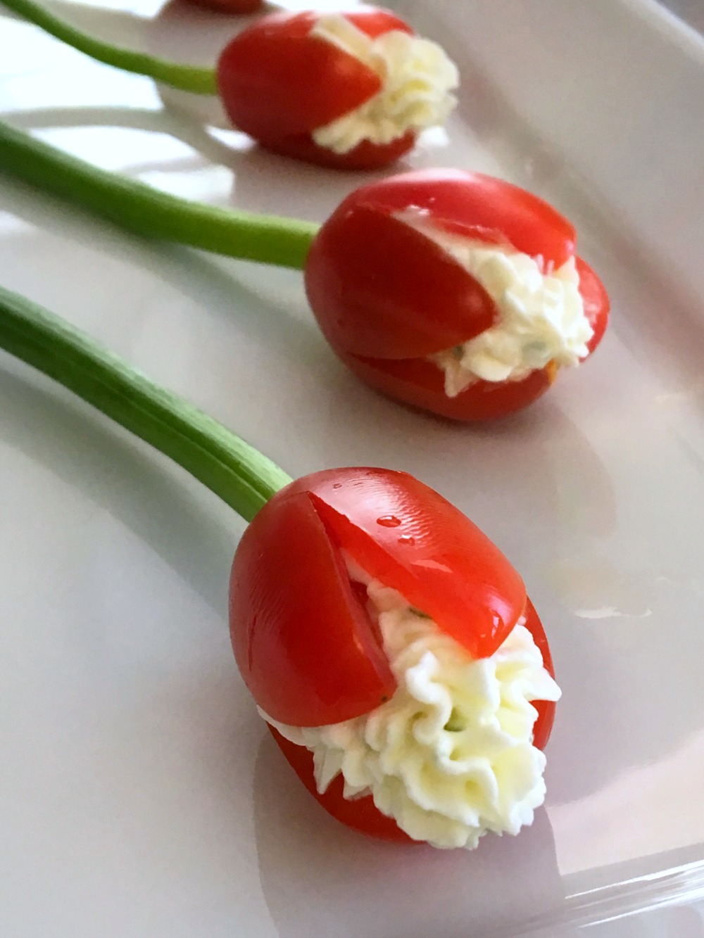 Grape Tomato Cream Cheese Tulips: A bunch of edible Tomato Tulips stuffed with garlicky chive cream cheese makes a pretty appetizer centerpiece for a special meal, a shower or party, or Mother’s Day.