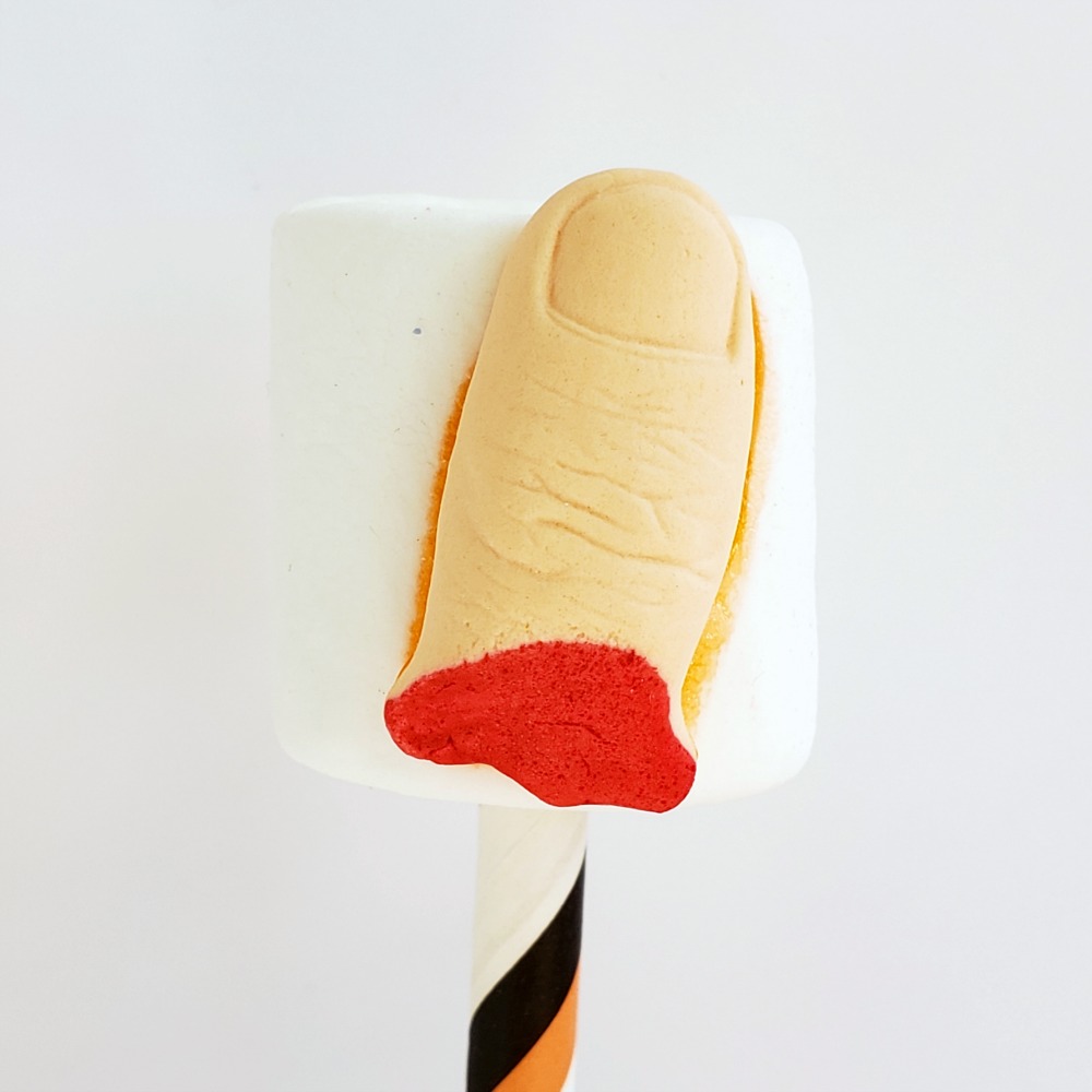 Severed finger candy on a marshmallow stuck in a striped straw on ShockinglyDelicious.com