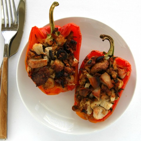 Striped Enjoya peppers stuffed with leftover Thanksgiving turkey and stuffing on a white plate against a white background. 