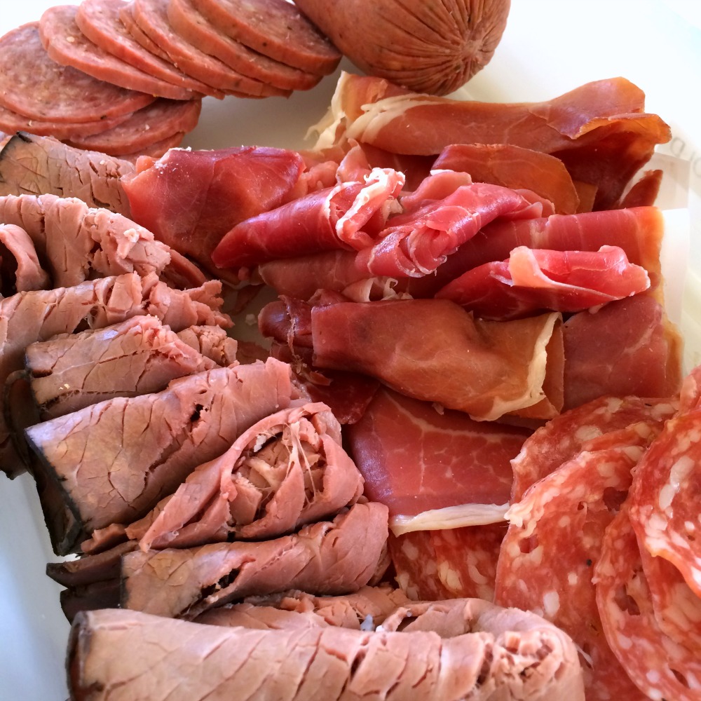 Various meat slices in a pile for a football-shaped meat plate